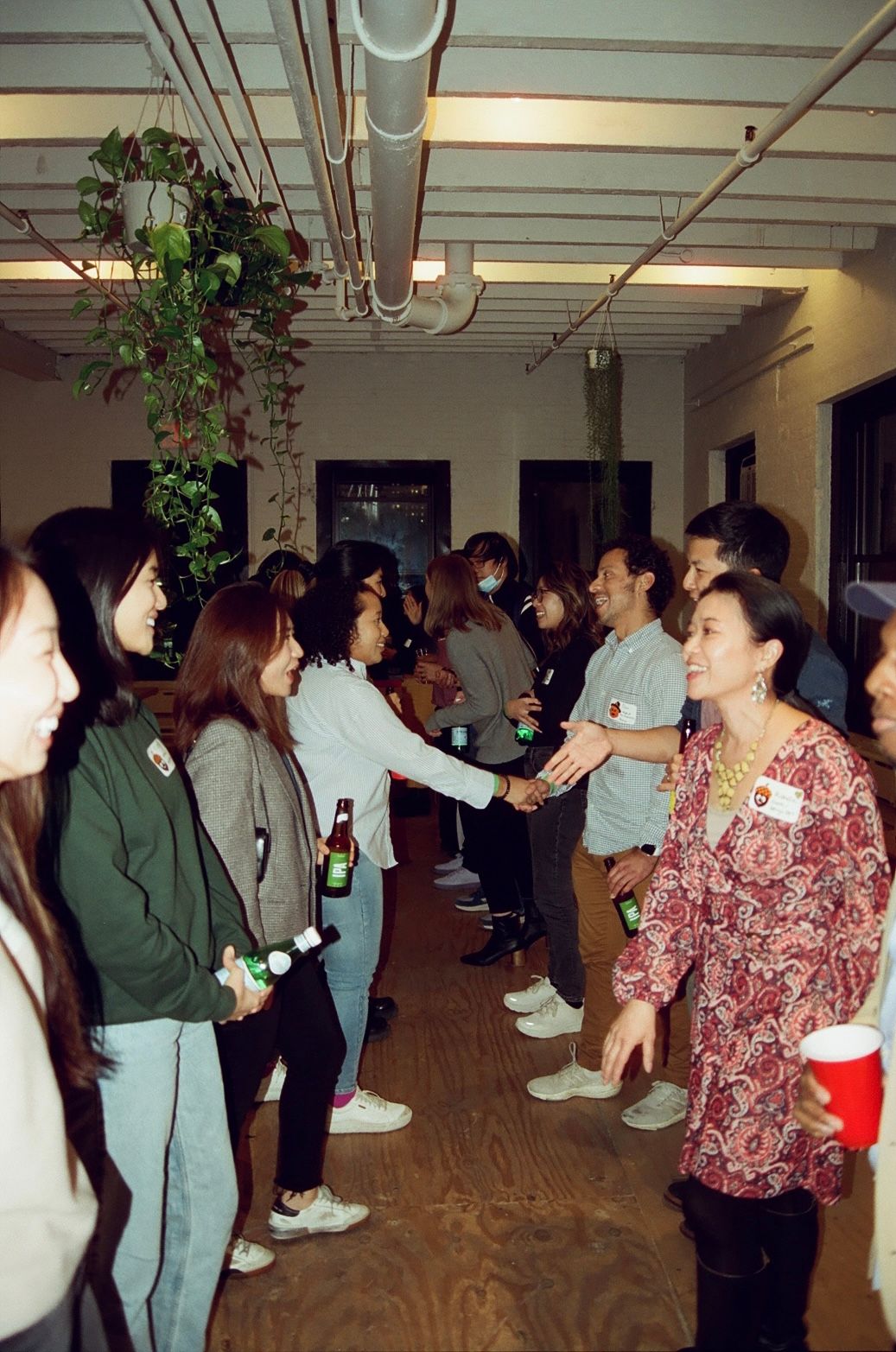 Two rows of standing people facing each other and talking.